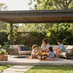 Familie unter einer freistehenden Terrassenüberdachung, die einen sonnigen Tag im Garten genießen.